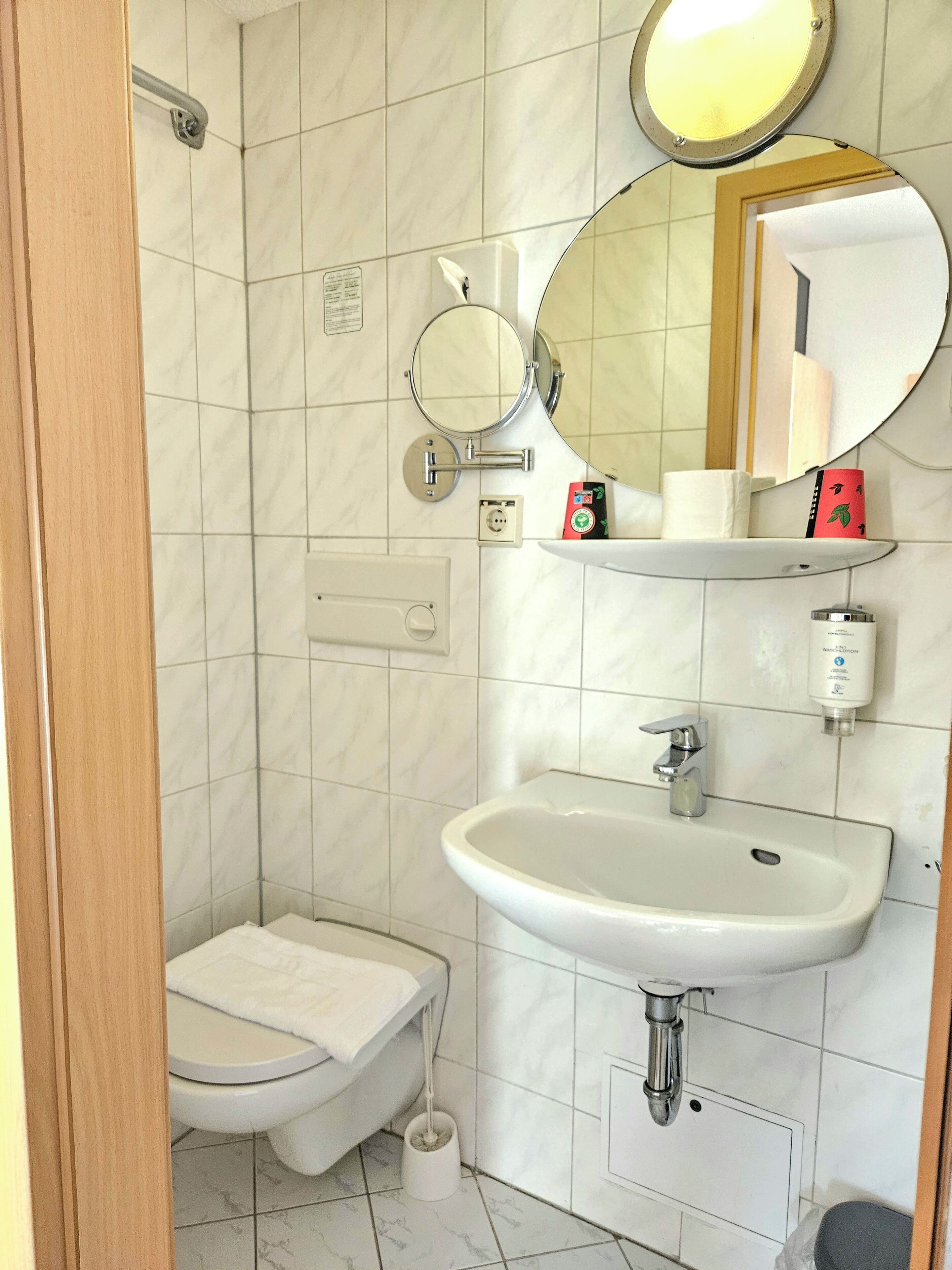 Un baño pequeño con inodoro, lavabo y espejo.