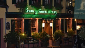 Un edificio con un letrero que dice "Zum grünen Engel" y un banderín con la palabra "RHEINGAU" a la vista.