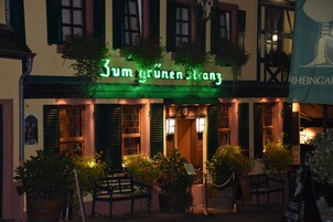 Un edificio con un letrero que dice "Zum grünen Engel" y un banderín con la palabra "RHEINGAU" a la vista.