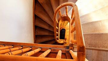 A wooden spiral staircase with a skylight above.