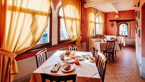 A dining area with a table set for breakfast, featuring plates, cutlery, and a pitcher of juice. - Dimora Casa Eugenia (Loro Ciuffenna)