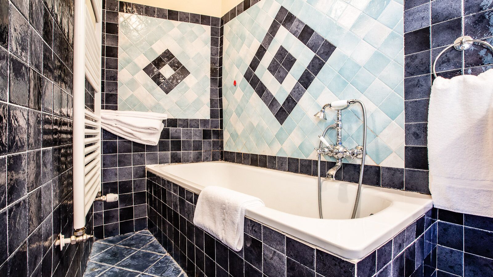 Ein Badezimmer mit Badewanne, Handtuchhalter und Duschbereich.
