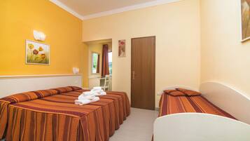 Une chambre d’hôtel avec deux lits, un bureau et une porte de salle de bain.