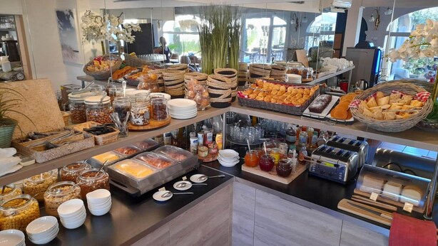 A buffet with various food items and condiments. - Hôtel Le Fabian des Baux (Les Baux-de-Provence)