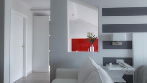 A modern bathroom with a white sink, a mirror, and a red accent wall. - Hotel Lombiña (Puebla del Caraminal)