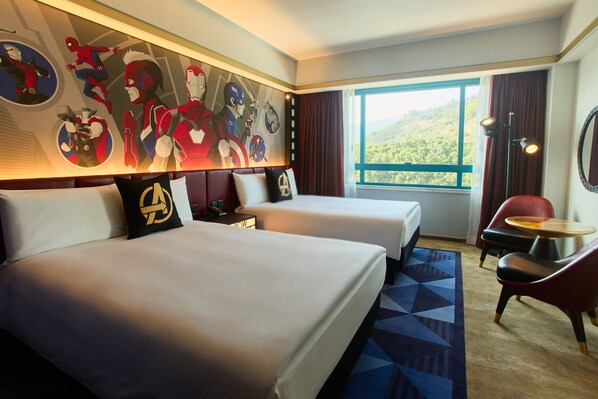 A hotel room with two beds, a large mural of superheroes, a view of a forest, and a red chair. - Disney's Hollywood Hotel (Lantau)