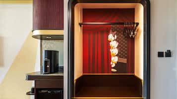 A kitchen with a coffee machine, a red curtain, and a Disney-themed wall decoration.