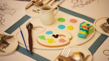 A dessert plate with colorful icing shapes, a white pitcher, and a paintbrush.