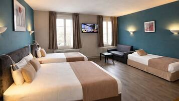 A hotel room with two beds, a television, and a sofa.