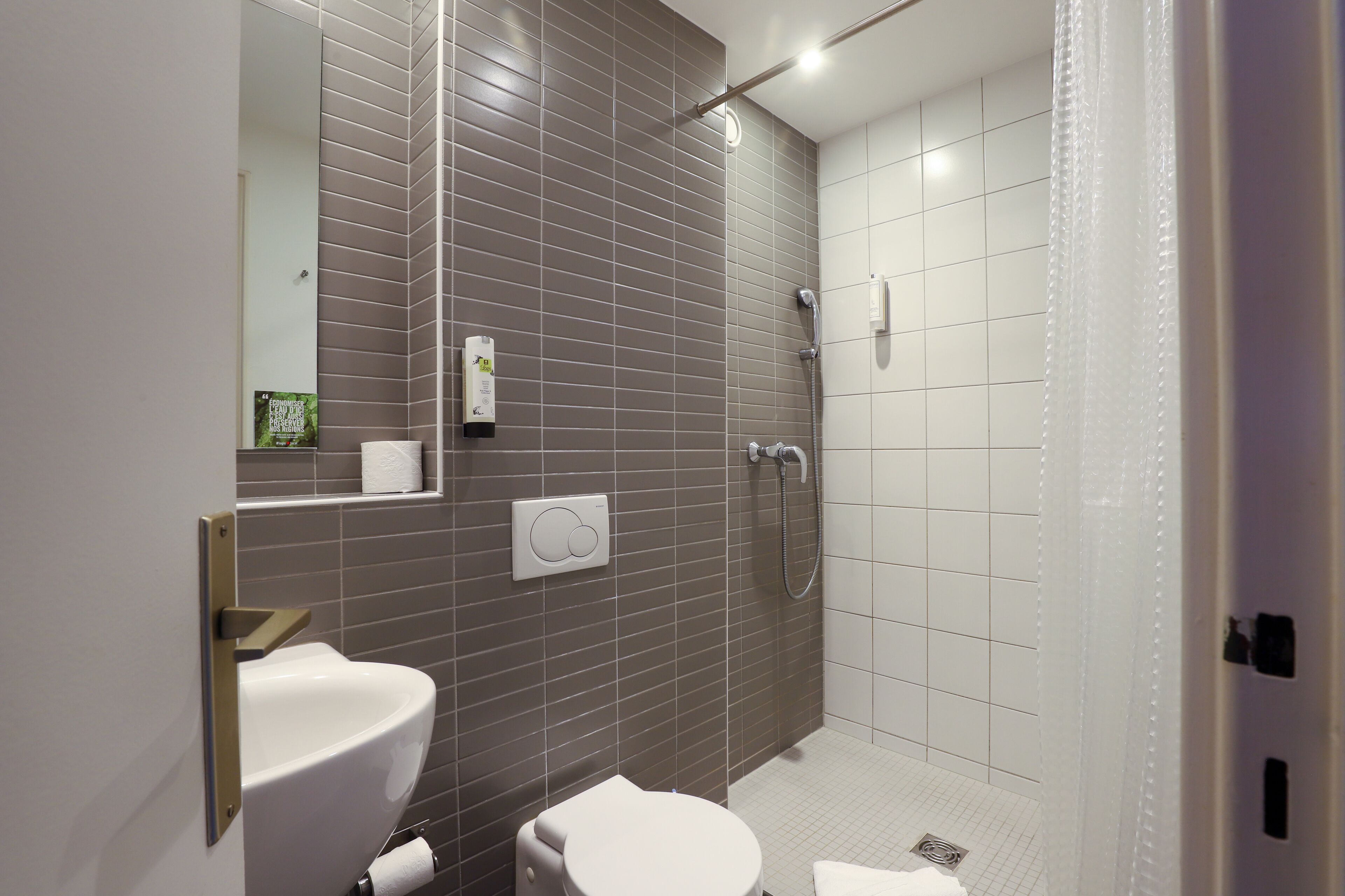A modern bathroom with a toilet, sink, and shower.