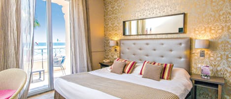 Habitación de hotel con una cama grande, una silla, una mesita de noche y vistas al exterior.