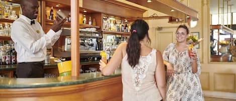 Zona de bar con un cantinero, una mujer sosteniendo una bebida y otra mujer con un ramo de flores.