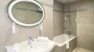 A bathroom with a sink, mirror, and shower.