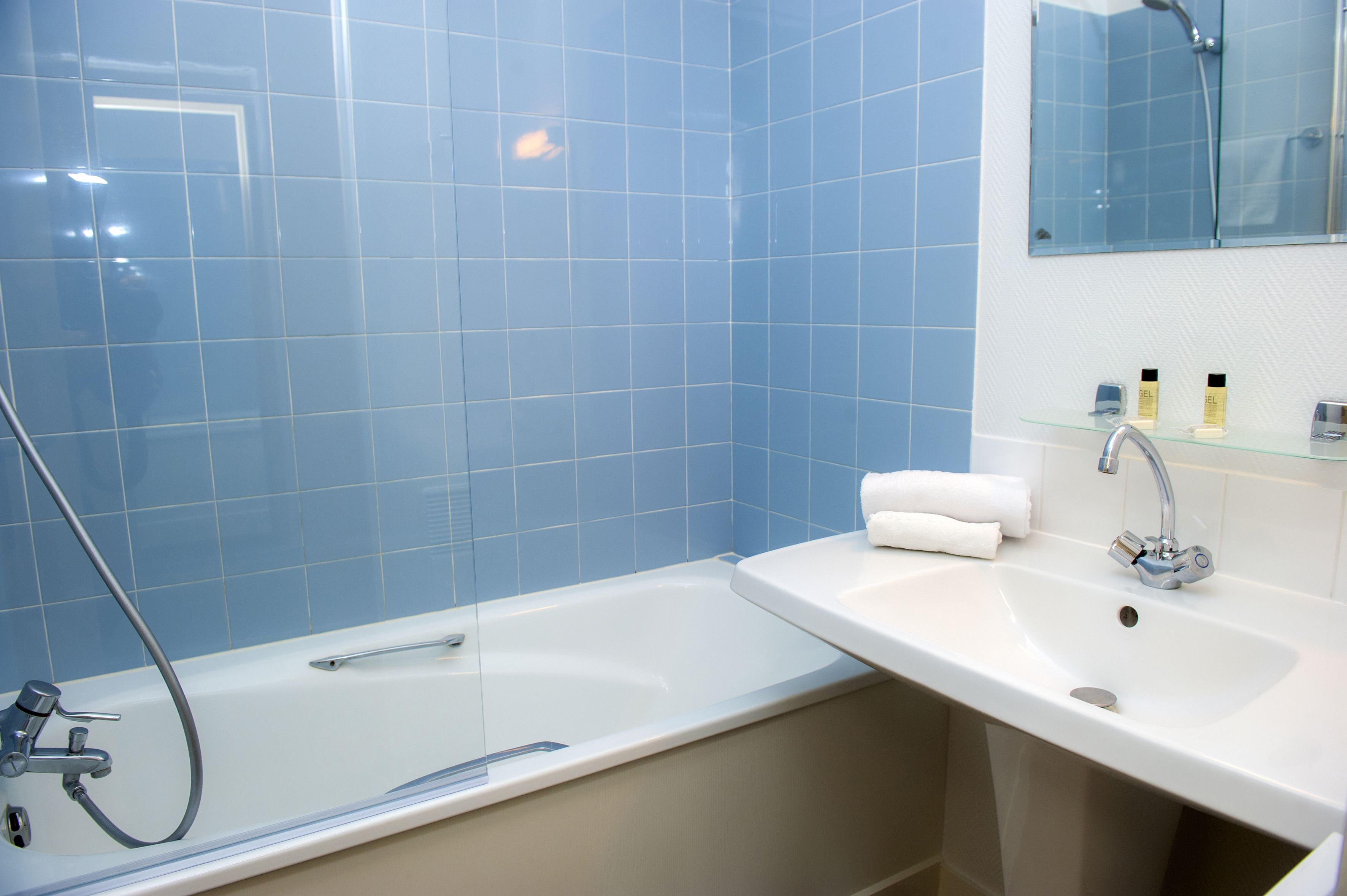 Une salle de bain moderne avec une baignoire, un lavabo et un miroir.