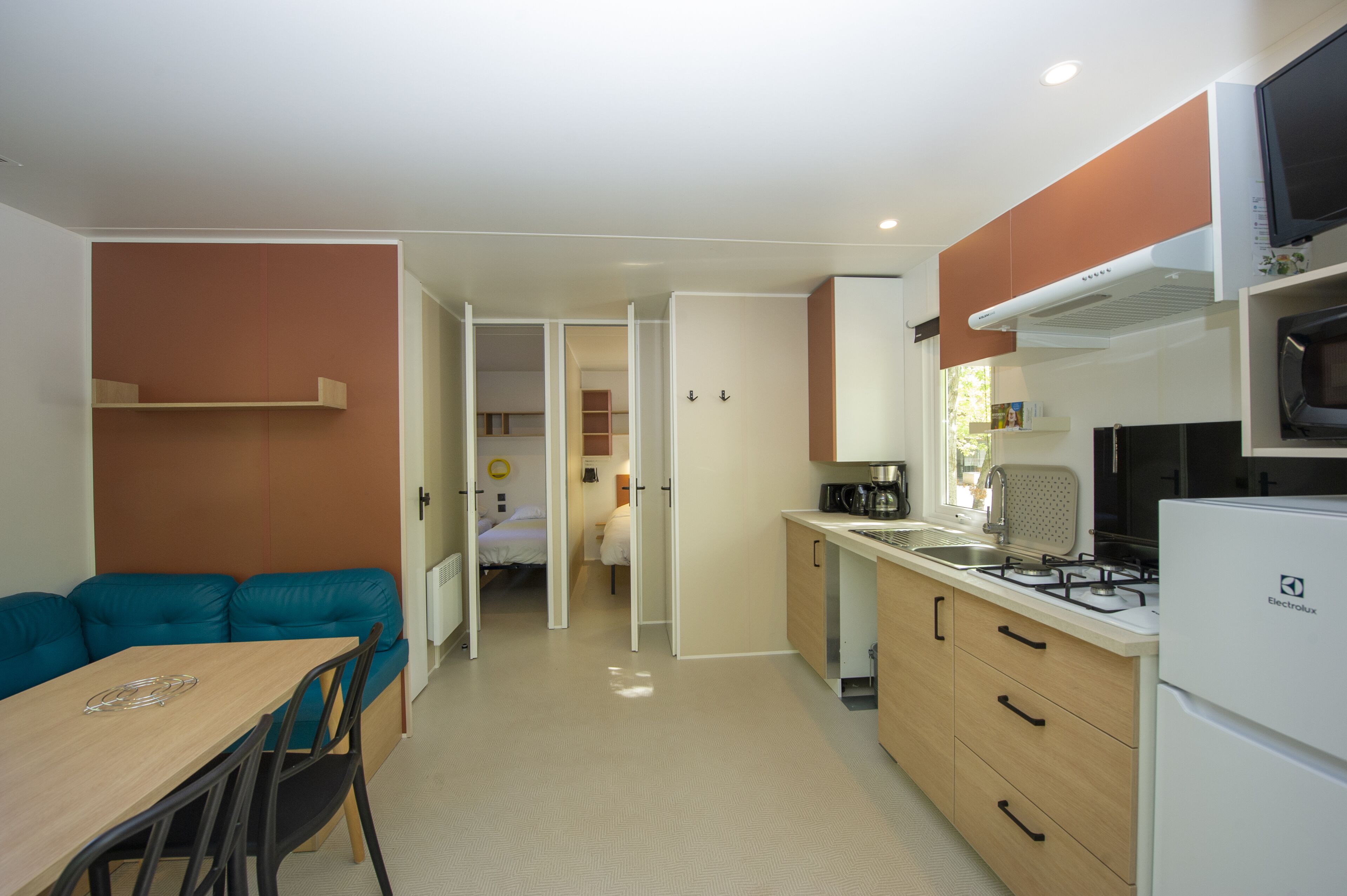 A compact kitchen with a gas stove, microwave, and a small dining area with a table and chairs.