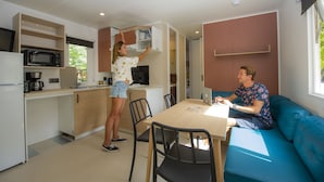 A modern kitchen with a microwave, coffee maker, and a dining area with a table and chairs.