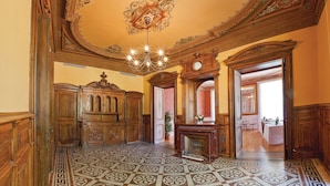 An ornate room with a patterned floor, a chandelier, wooden furniture, and a fireplace. - Club Vacances Bleues Domaine de Château Laval (Gréoux-les-Bains)