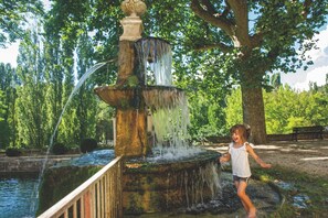 A child playing near a multi-tiered water fountain in a park. - Club Vacances Bleues Domaine de Château Laval (Gréoux-les-Bains)