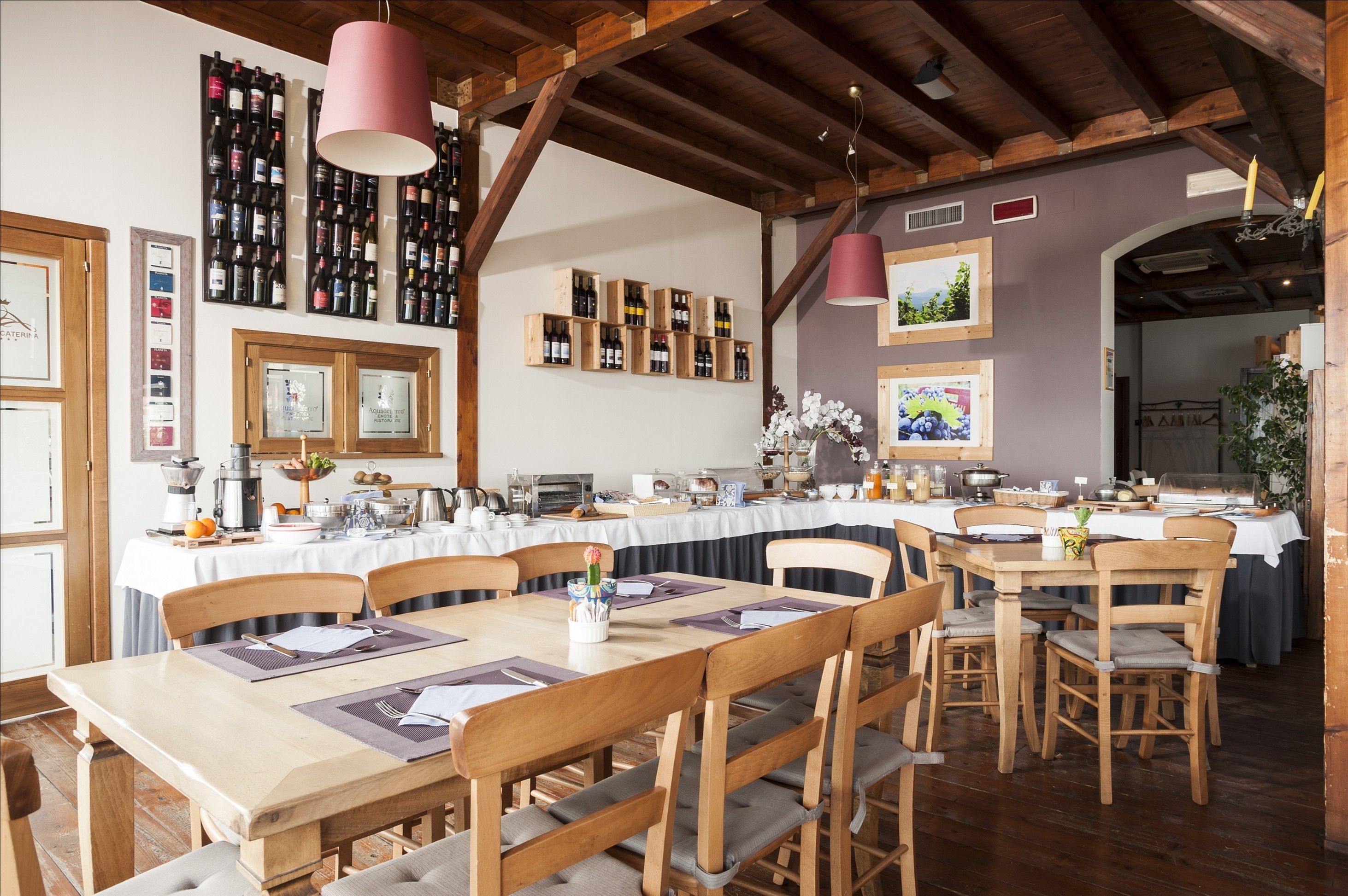 A dining area with wooden tables and chairs, a wine rack, and framed pictures on the walls.