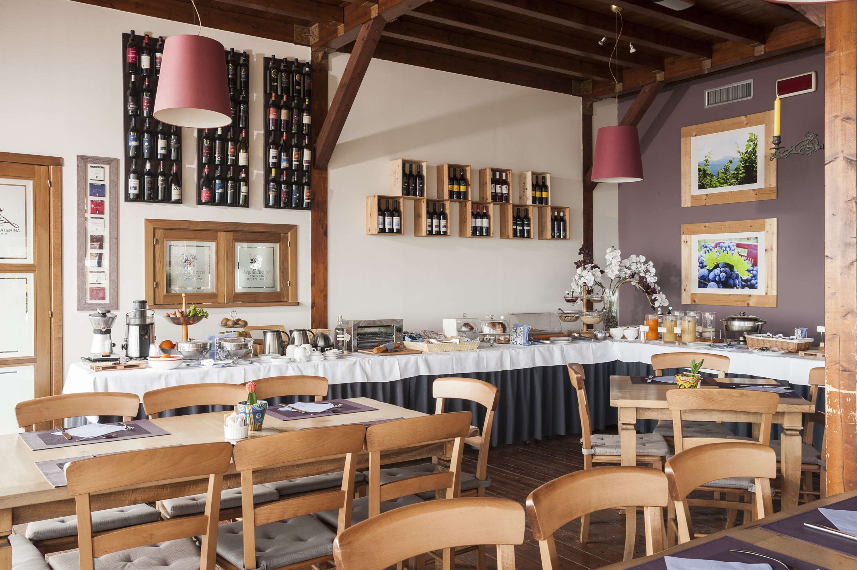 Un restaurante con mesas y sillas de madera, una barra larga con botellas de vino y cuadros en las paredes.