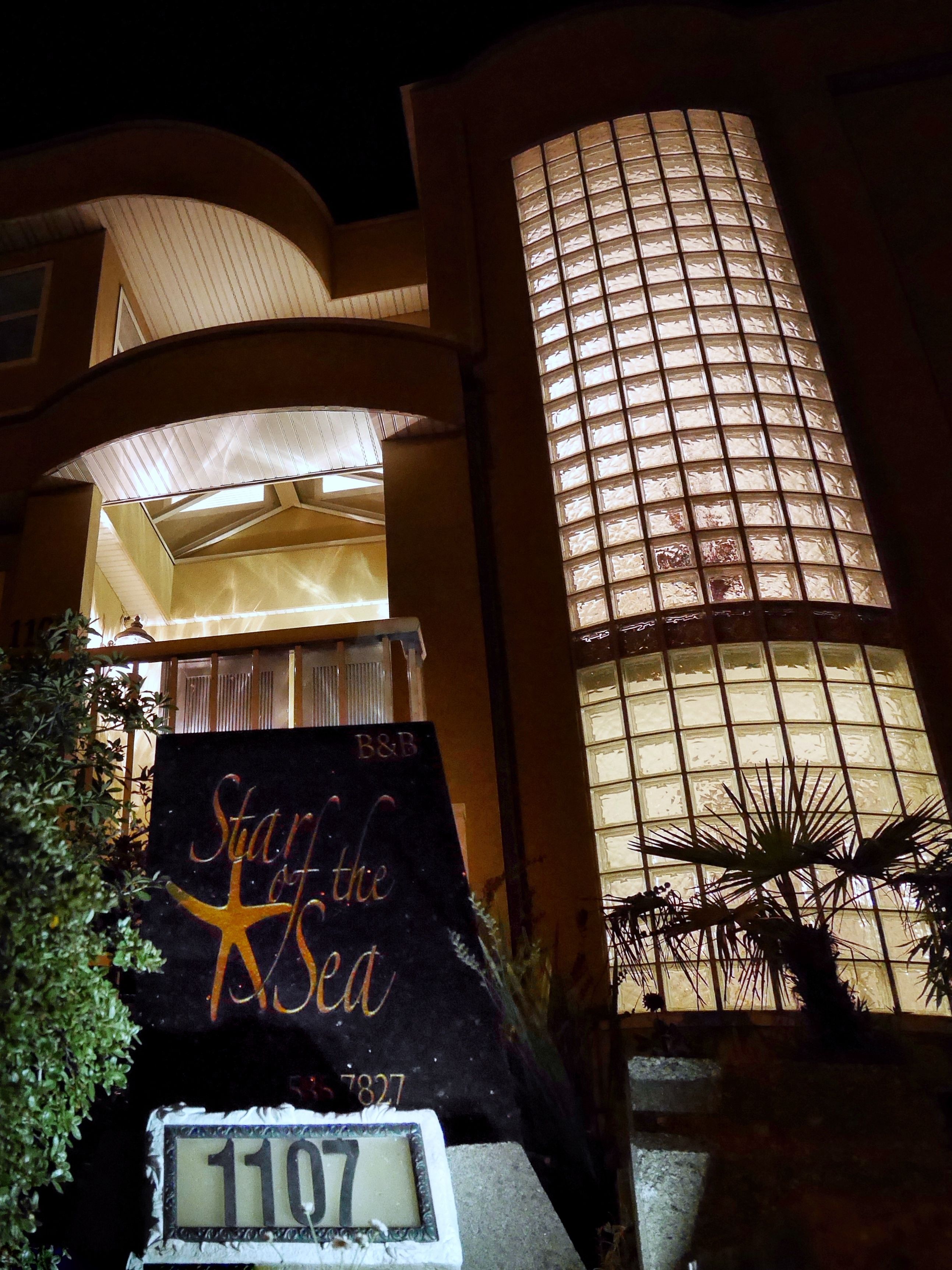 A building with a large illuminated window and a sign that reads "Star of the Sea".