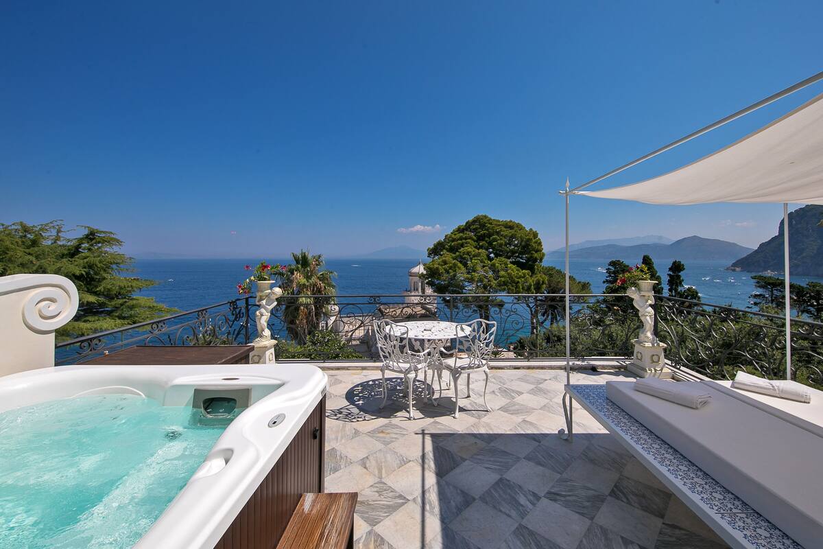 Un jacuzzi, asientos al aire libre y una vista panorámica al océano.
