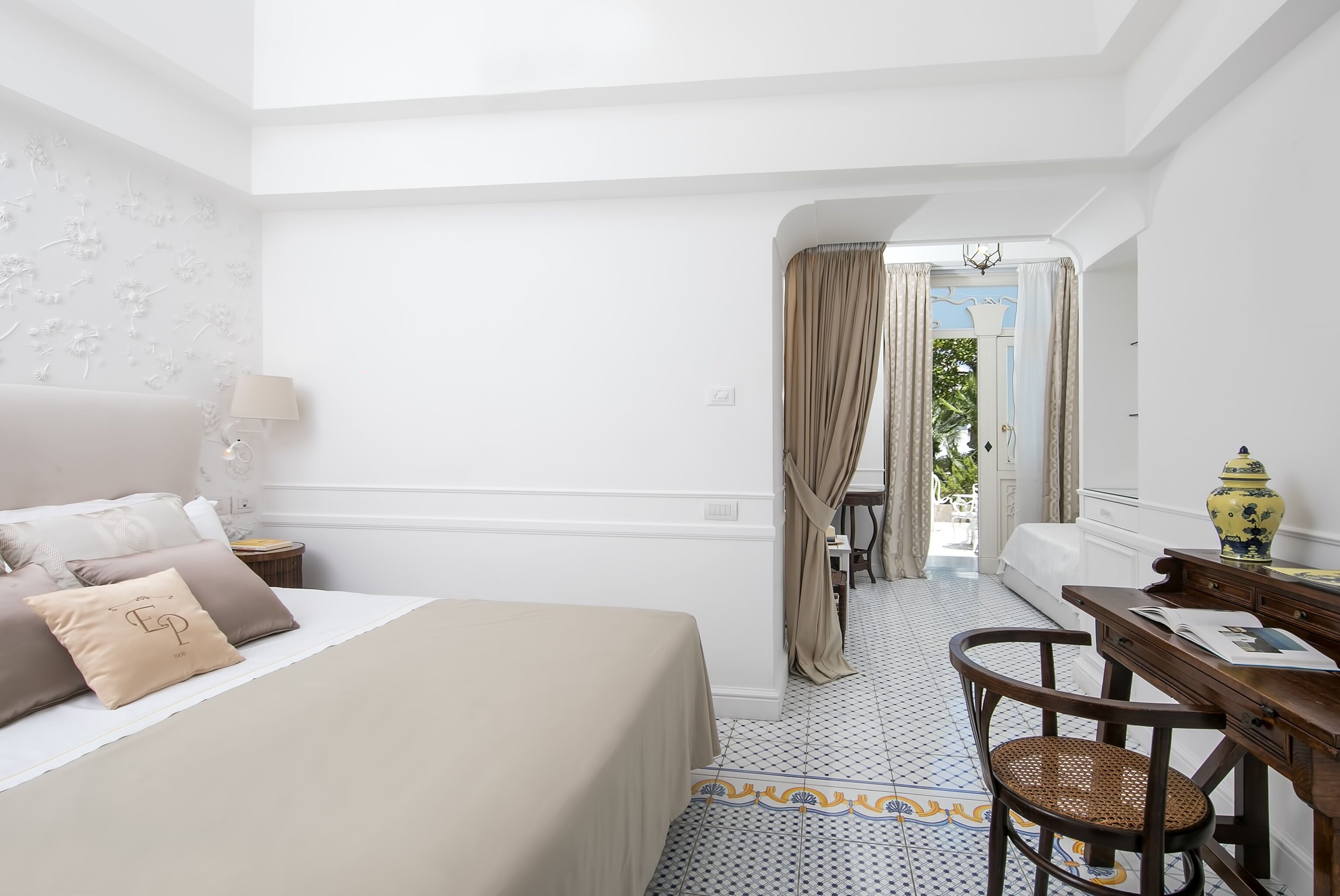Ein Hotelzimmer mit Bett, Schreibtisch, Stuhl und Blick ins Freie.