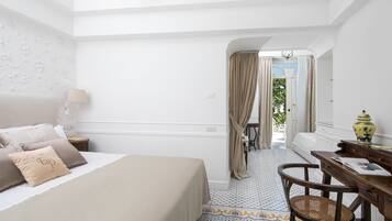 Ein Hotelzimmer mit Bett, Schreibtisch, Stuhl und Blick ins Freie.