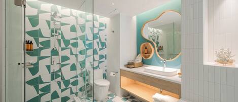 A modern bathroom with a glass shower enclosure, a white toilet, a sink with a wooden vanity, and a bathtub.