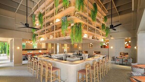 A modern bar area with a central island, multiple seating options, and hanging greenery. - Centara Karon Resort Phuket (Karon)