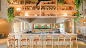 A modern bar area with a central island, bar stools, and hanging plants. - Centara Karon Resort Phuket (Karon)