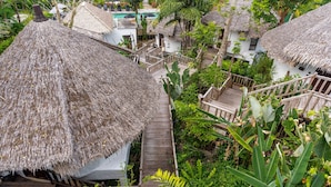 A tropical resort with thatched-roof huts, wooden walkways, and lush greenery. - Aana Resort & Spa (Ko Chang)