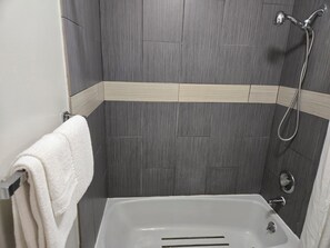 Une salle de bain avec une douche, une baignoire et un porte-serviettes.