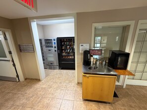 A hotel room with a kitchenette, a vending machine, and a coffee machine. - London Travel Inn (London)