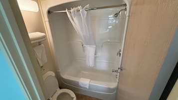 A bathroom with a toilet, a bathtub, and a shower curtain.