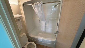A bathroom with a toilet, a bathtub, and a shower curtain.