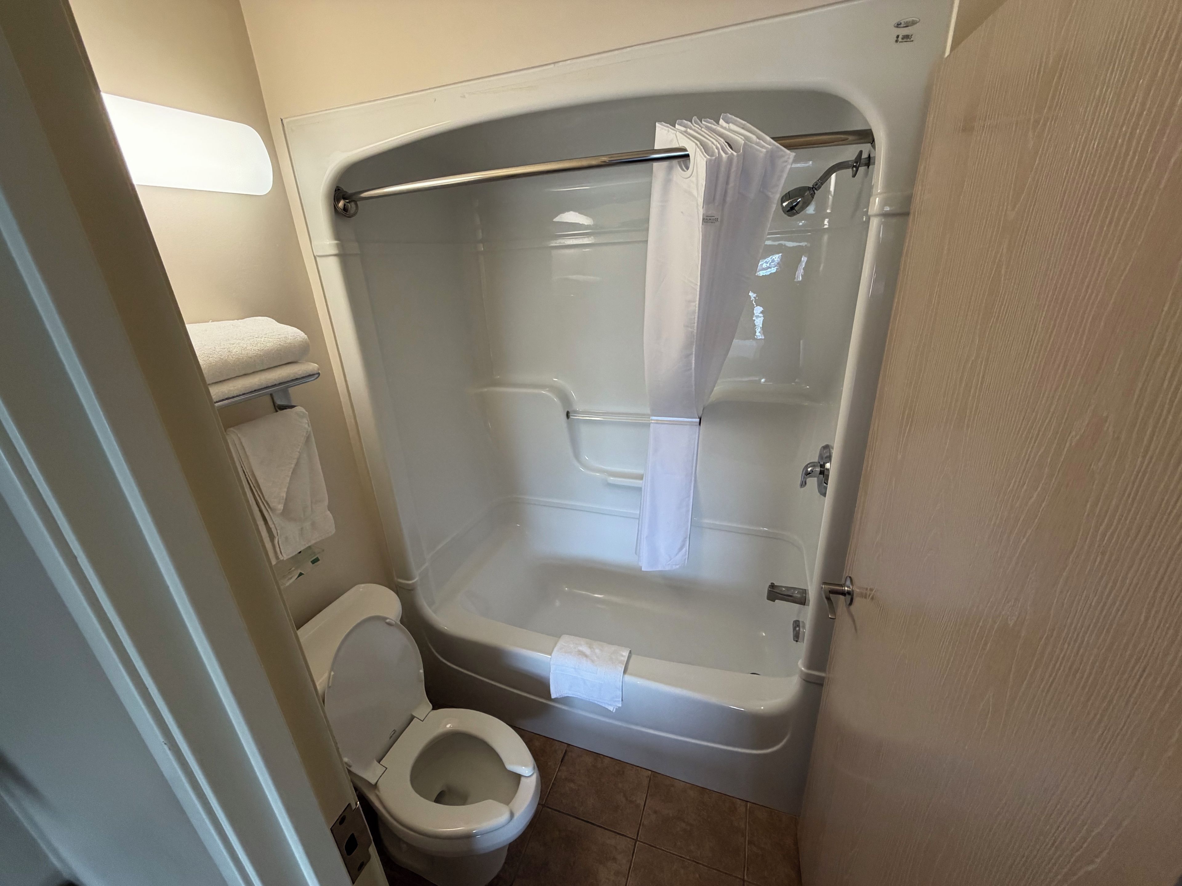 Un baño con bañera, inodoro y barra para toallas.