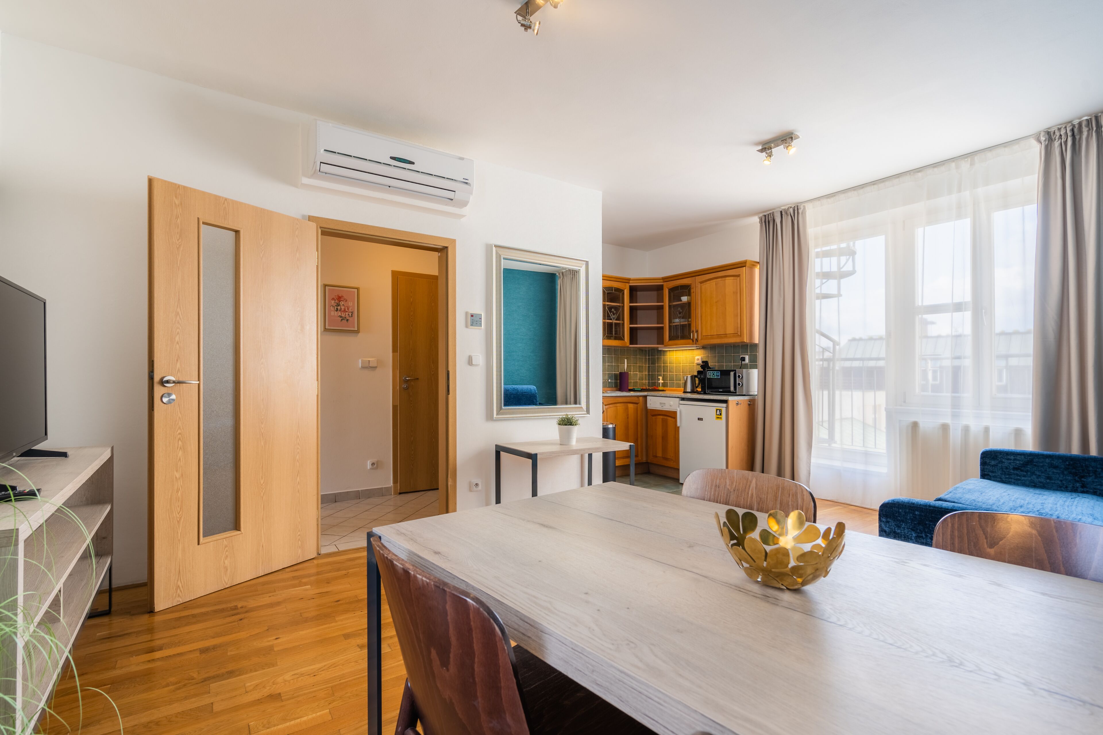A modern apartment with a dining area, kitchen, and living space.