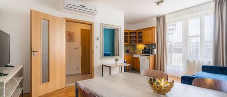 A modern apartment with a dining area, kitchen, and living space.