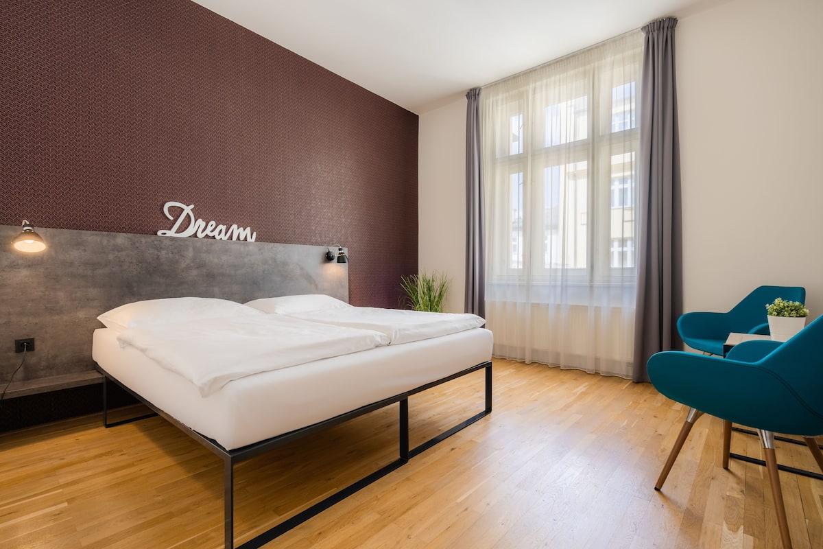 Une chambre d’hôtel moderne, équipée d’un lit, d’un bureau et d’une chaise.