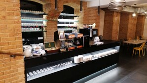 A coffee shop counter with a display of cups and a coffee machine.