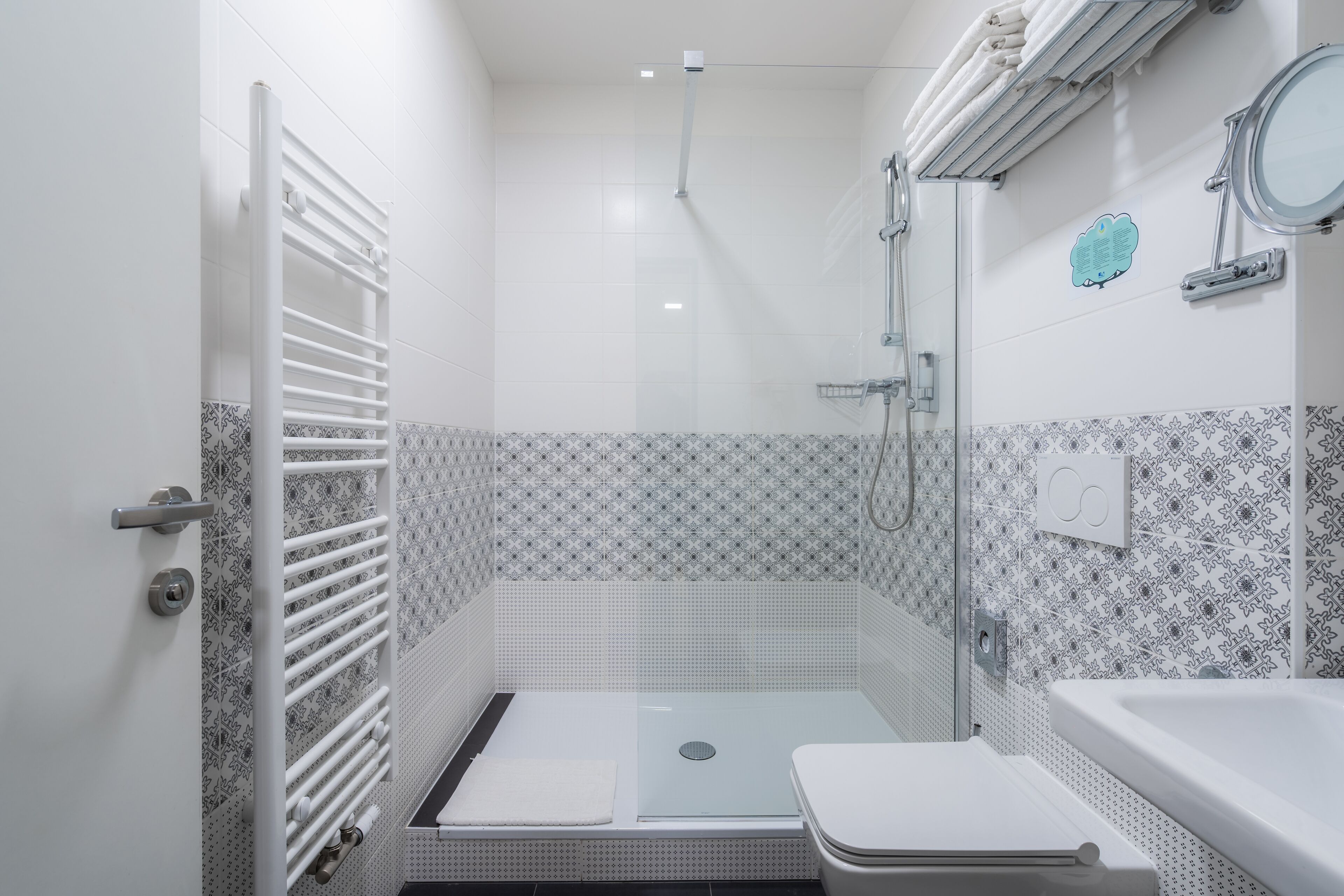 Une petite salle de bain moderne équipée d’une douche, de toilettes et d’un porte-serviettes.