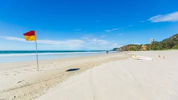 Beach nearby, white sand, beach towels, surfing