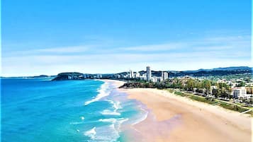 Beach nearby, white sand, beach towels, surfing