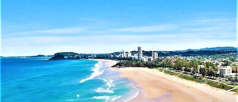 Beach nearby, white sand, beach towels, surfing