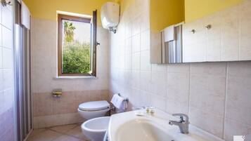 Un baño con inodoro, bidé y lavamanos.