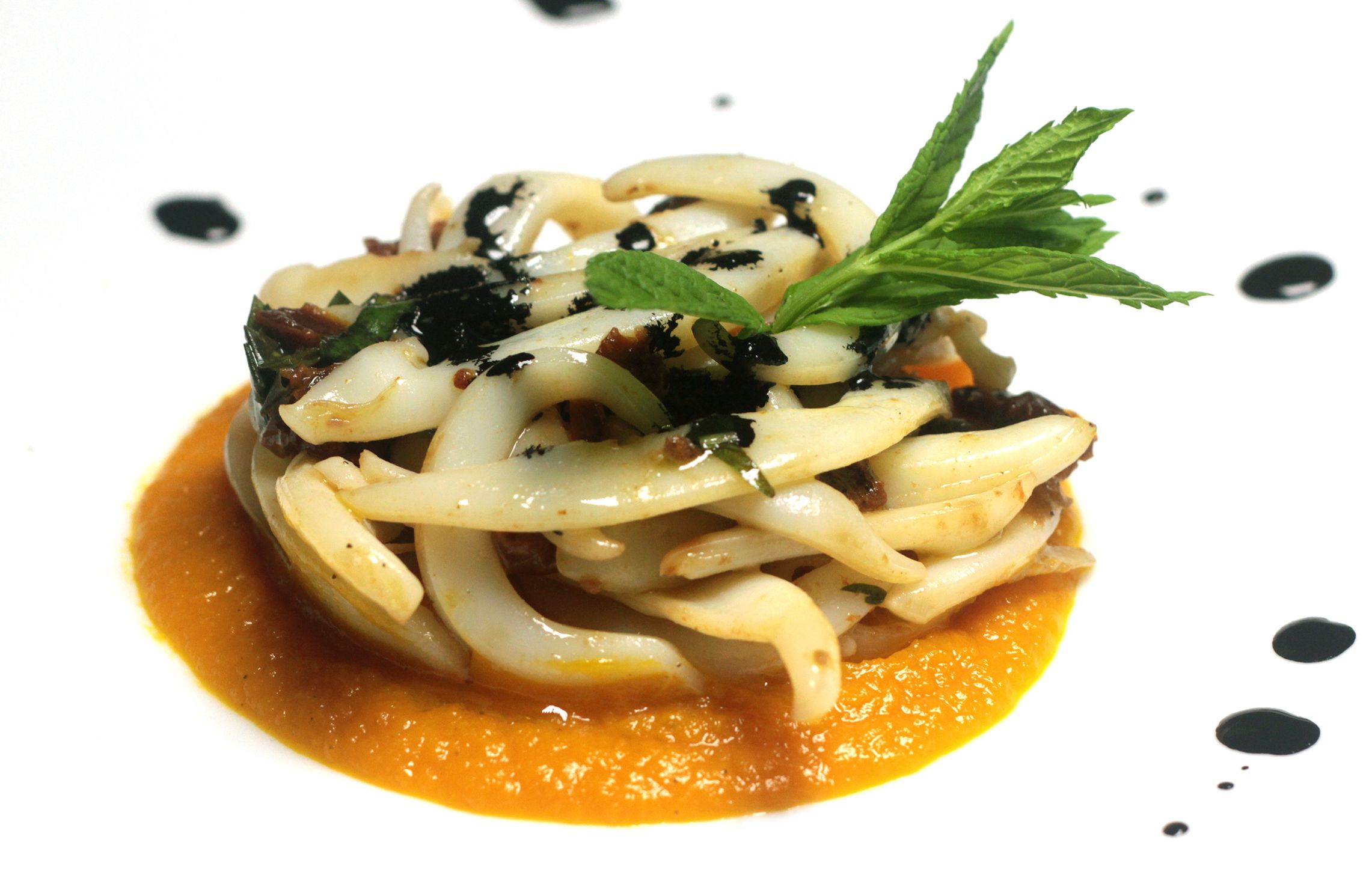 Eine Portion Pasta mit grünen Blättern und einem Soßenüberzug.