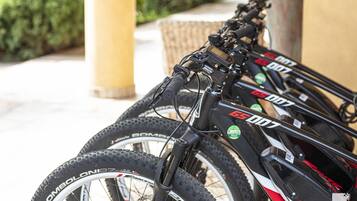 A row of mountain bikes with 'GS 007' branding, equipped with front suspension forks and mounted on a stand.
