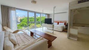 Een moderne hotelkamer met een groot raam, een bed, een nachtkastje, een televisie en een kledingkast.