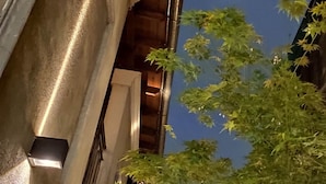 A building exterior at night with a visible staircase and a tree in the foreground. -  Posada Gotan (Buenos Aires)